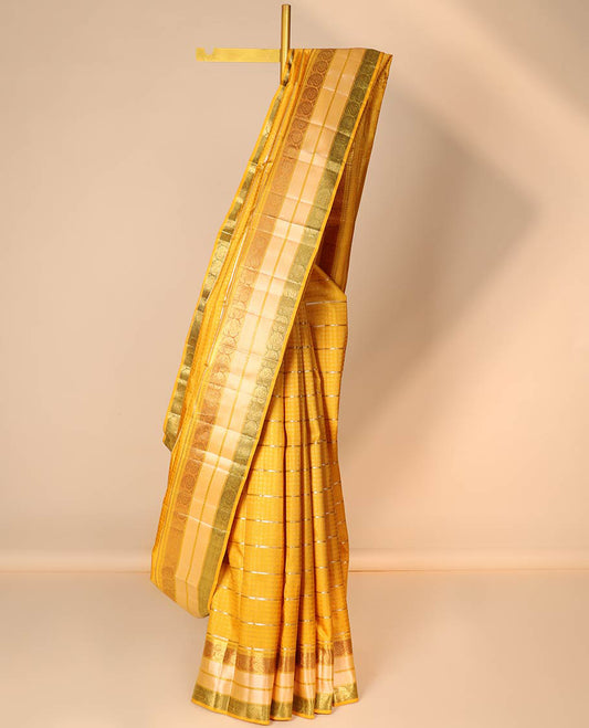 Yellow embossed silk saree with sparkling zari stripes, intricate pallu & zari border of thilakam mokku & manga designs