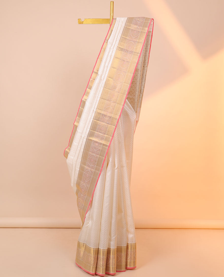 Cream embossed silksaree with buttas, contrast jaal pallu & border of rekku,poun,zari stripes &  chakram