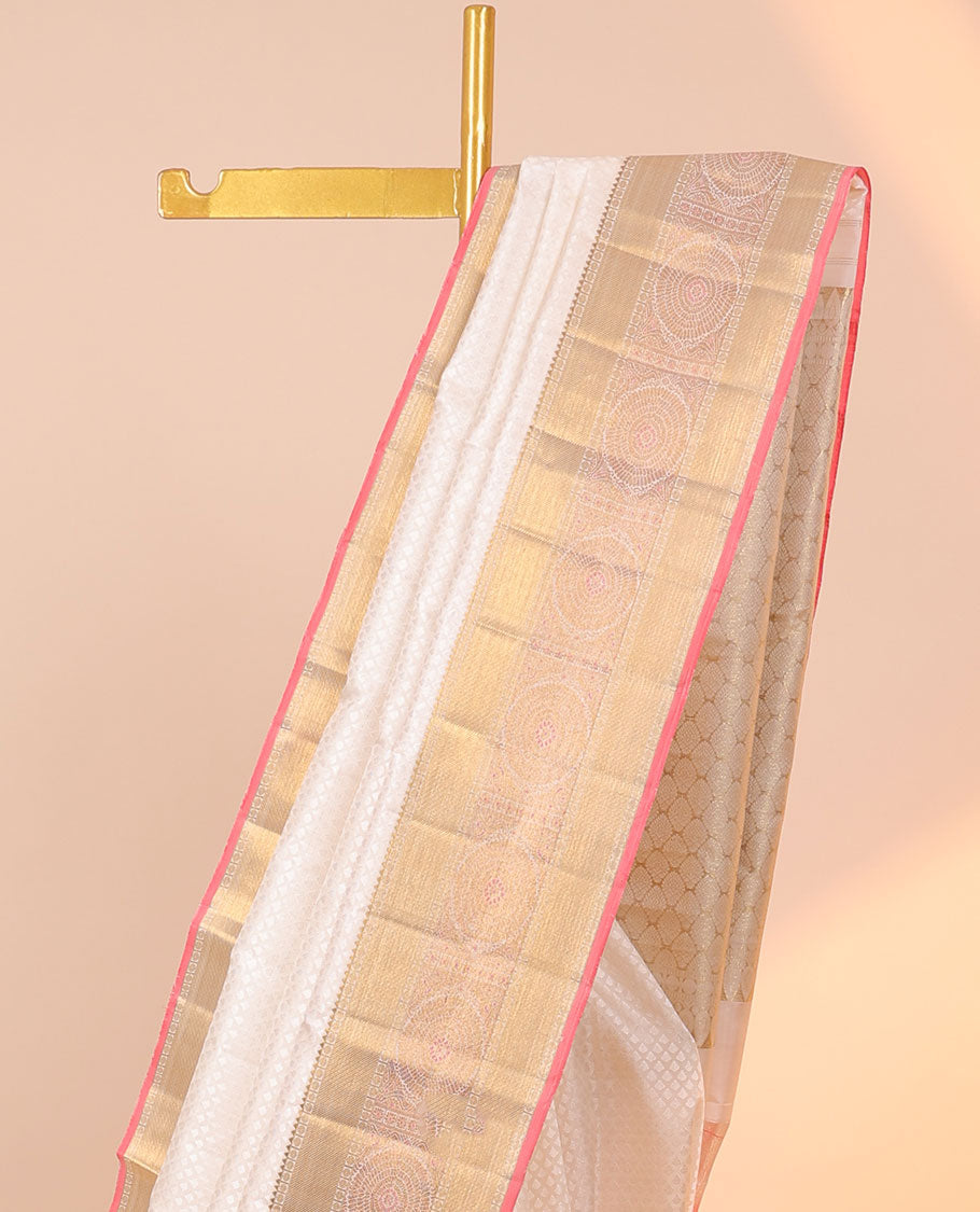 Cream embossed silksaree with buttas, contrast jaal pallu & border of rekku,poun,zari stripes &  chakram