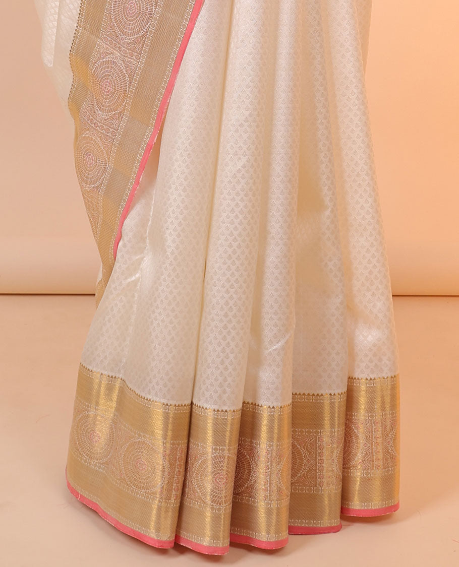 Cream embossed silksaree with buttas, contrast jaal pallu & border of rekku,poun,zari stripes &  chakram