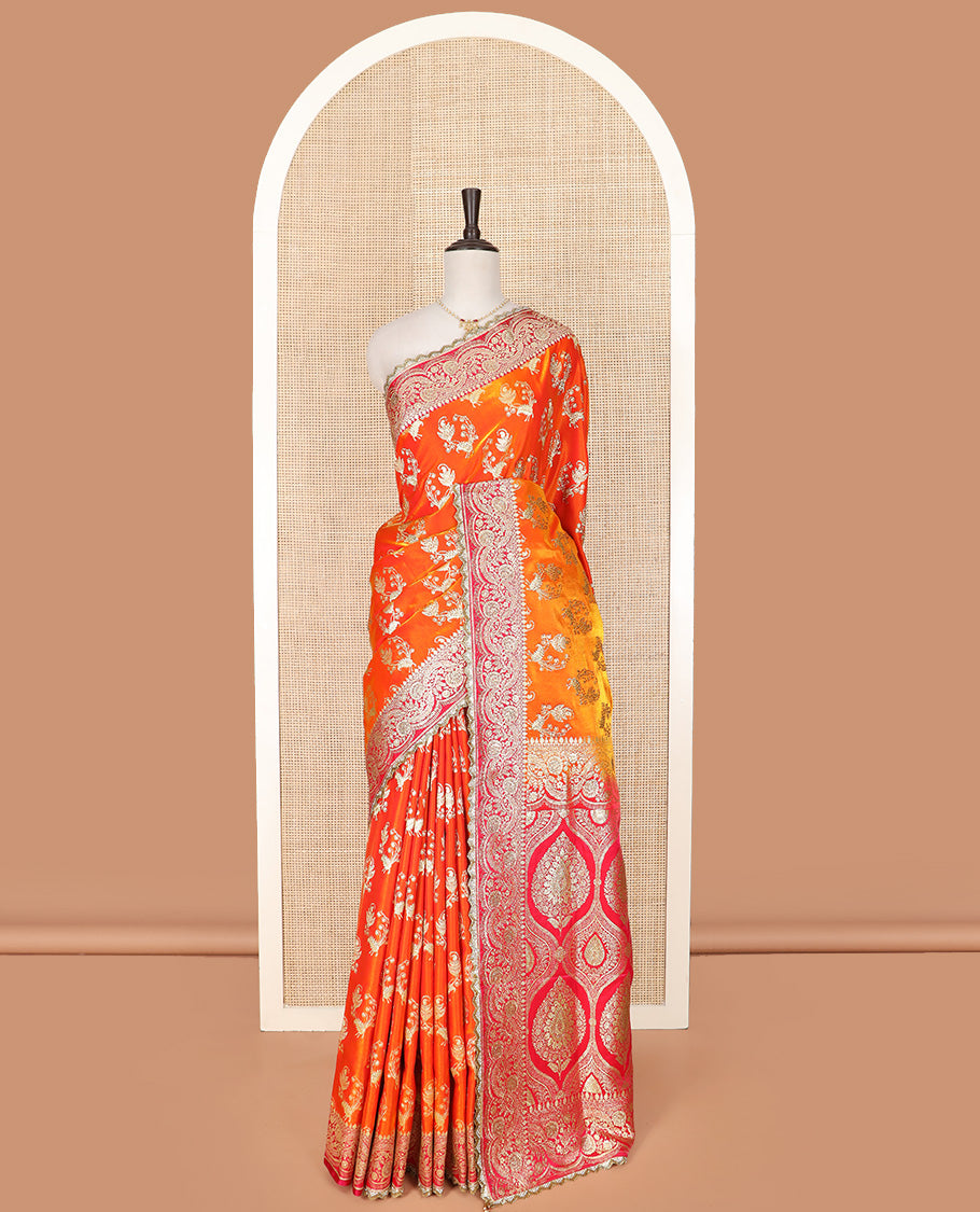 Orange Art Vastrakala Silk Saree Bedecked with Zari Buttas with Stone Work All Over Its Body, Complemented by a Contrast Floral Scallop Design Zari Stone Work Border, Mughal-Design Pallu Detailed in Zari and Stone Work, and Paired with a Contrast Blouse
