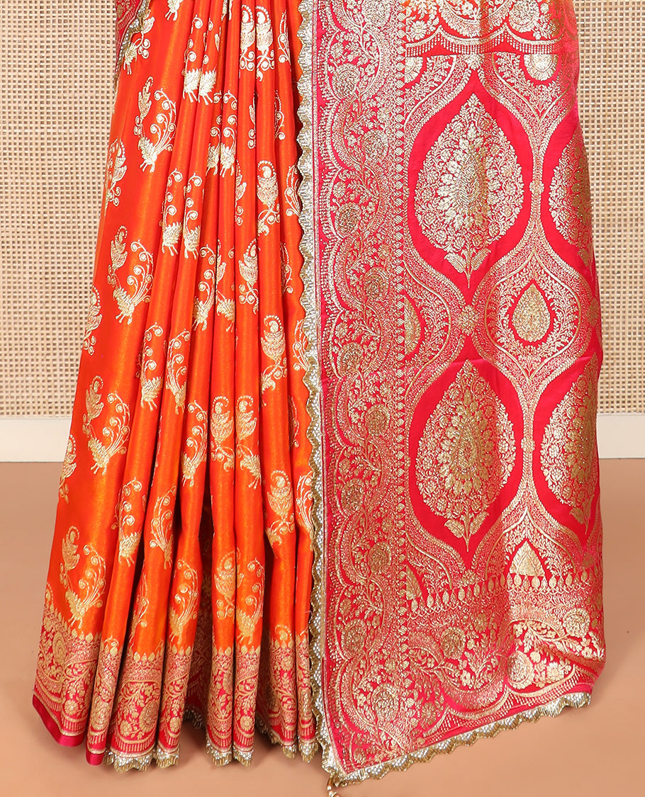 Orange Art Vastrakala Silk Saree Bedecked with Zari Buttas with Stone Work All Over Its Body, Complemented by a Contrast Floral Scallop Design Zari Stone Work Border, Mughal-Design Pallu Detailed in Zari and Stone Work, and Paired with a Contrast Blouse