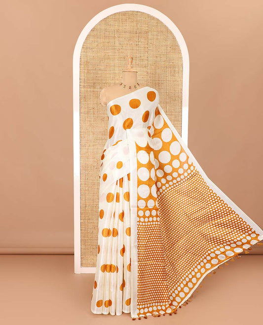 Borderless cream and orange polka dots printed art khadi cotton saree, pallu steeped with polka dots, and a contrast tiny polka dots printed blouse