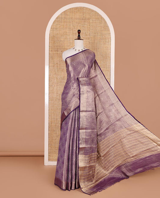 Purple scallop design tissue saree, zari striped border, striped pallu, and gleaming matching blouse