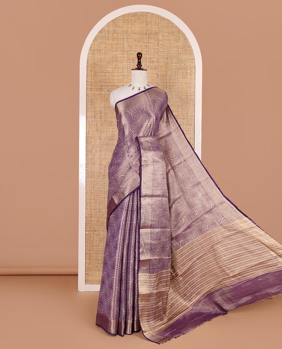 Purple scallop design tissue saree, zari striped border, striped pallu, and gleaming matching blouse
