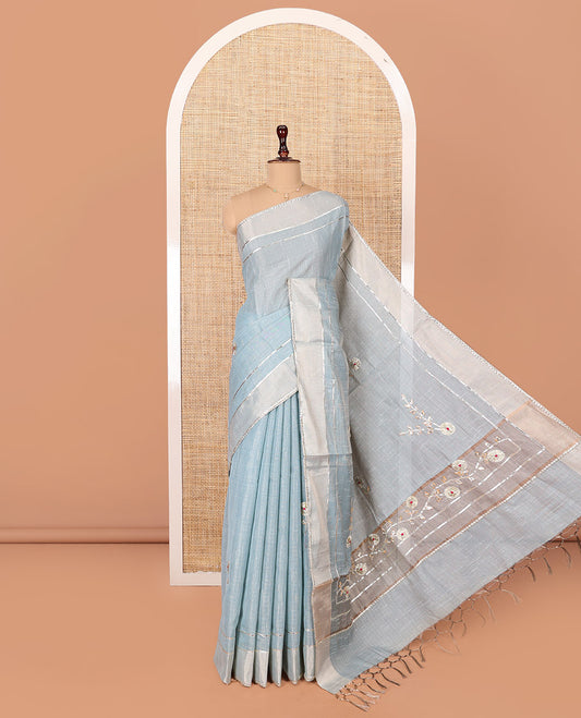 Grey Tissue Cotton Saree, Subtly Sparkled with Checks and Floral Motifs Embroidery on Its Body, Complemented by Plain Lace Border, Pallu Spotlighted with Floral Motifs Embroidery, and Paired with a Matching Blouse