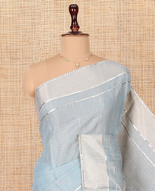Grey Tissue Cotton Saree, Subtly Sparkled with Checks and Floral Motifs Embroidery on Its Body, Complemented by Plain Lace Border, Pallu Spotlighted with Floral Motifs Embroidery, and Paired with a Matching Blouse