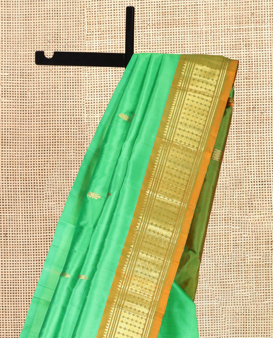 Green Kanchipuram Silk Saree, Styled with Zari Buttas, a Contrast One-Sided Border of Rekku, Banaras, and Rudraksham Designs, Zari Design Pallu, and a No Blouse