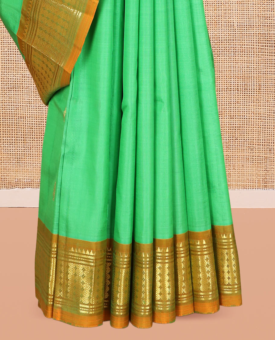 Green Kanchipuram Silk Saree, Styled with Zari Buttas, a Contrast One-Sided Border of Rekku, Banaras, and Rudraksham Designs, Zari Design Pallu, and a No Blouse