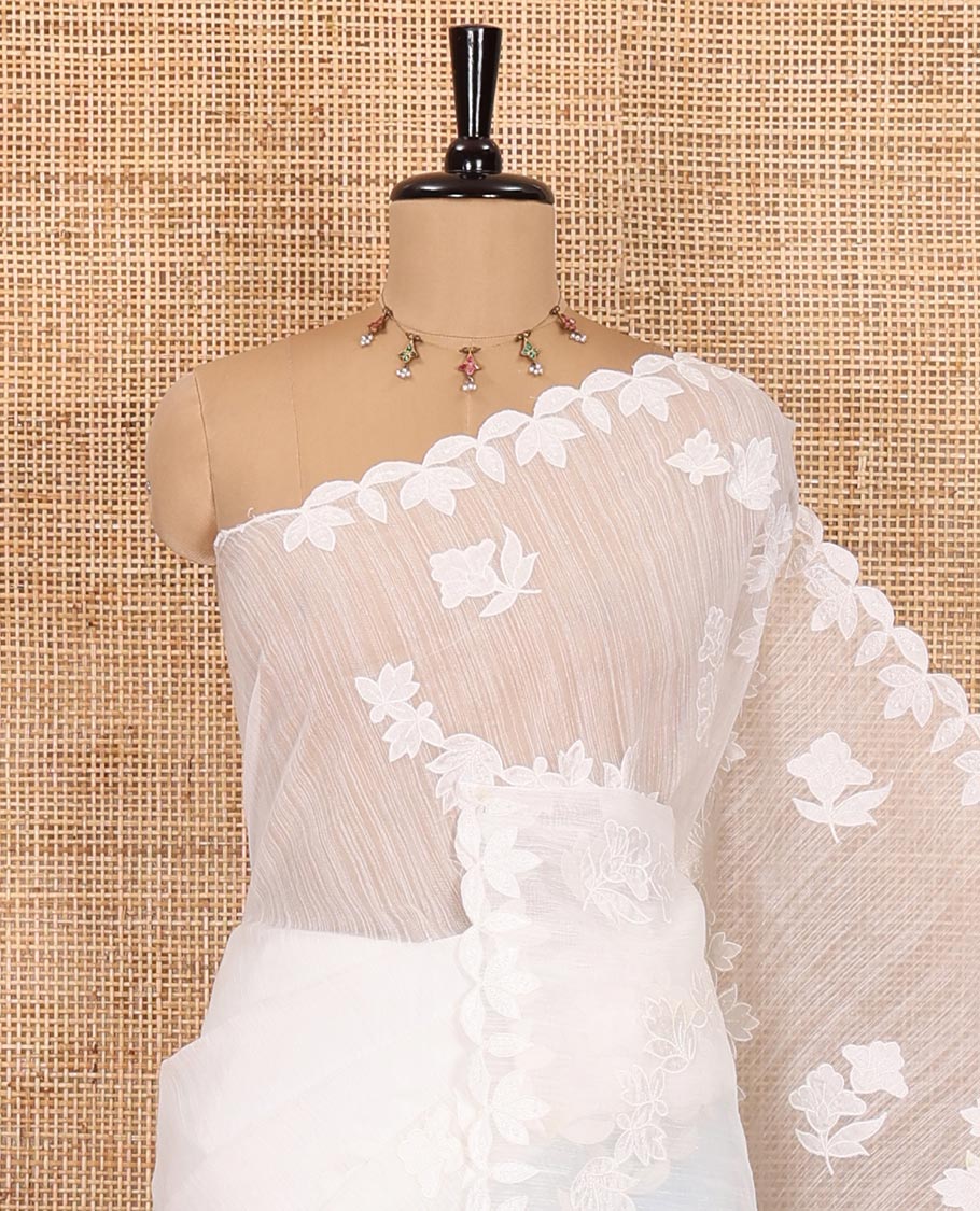 White floral motifs and diagonal floral creeper applique embroidered linen saree, scallop border, floral embroidered pallu, and a plain blouse