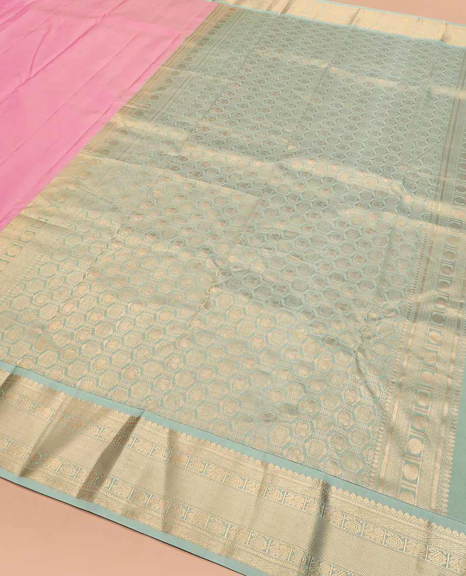 Pink zari buttas silk saree, contrast border of thilakam mokku, jaal, manga, and mayil designs, and Mughal-style intricate pallu