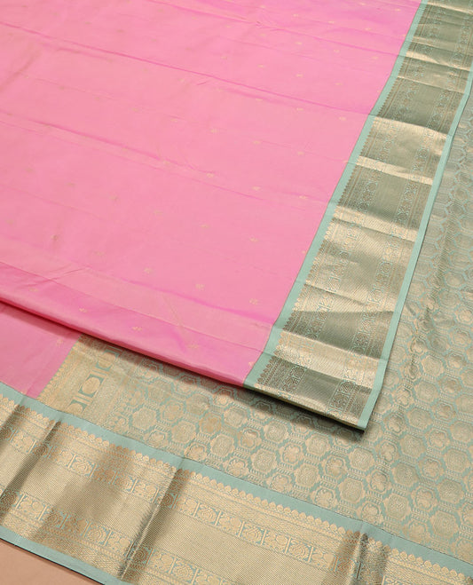 Pink zari buttas silk saree, contrast border of thilakam mokku, jaal, manga, and mayil designs, and Mughal-style intricate pallu