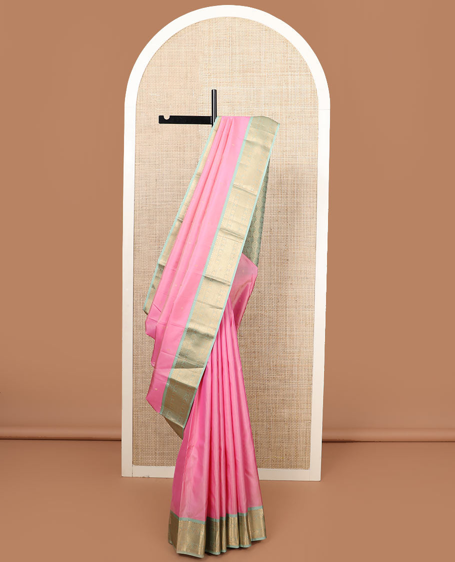 Pink zari buttas silk saree, contrast border of thilakam mokku, jaal, manga, and mayil designs, and Mughal-style intricate pallu