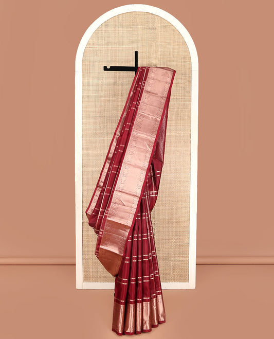 Maroon Vasundhara Silk Saree, Artfully Detailed with Buttas and Checked Design on Its Body, Highlighted by Zari Border of Manga Mokku, Poun, Mayil, and Mayil Kann Designs, Pallu of Geometric Designs, and Paired with a Matching Blouse