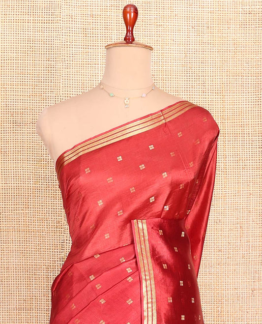 Candy Red Banana Pith Saree Mesmerized with Square-Shaped Zari Buttas, Subtly Woven Zari Piping Border, Pallu Gleamed Up with Zari Stripes, and Paired with a Matching Blouse