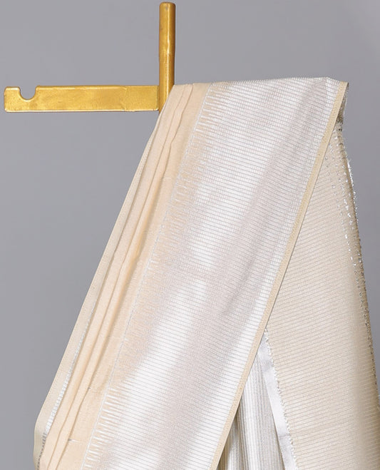 Cream semi-banaras dola silk saree with buttas, zari-rich traditional temple border, and pallu