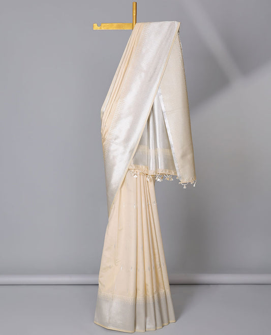 Cream semi-banaras dola silk saree with buttas, zari-rich traditional temple border, and pallu