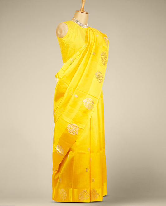 Yellow banaras raw mango silk saree features floral zari buttas, floral design border