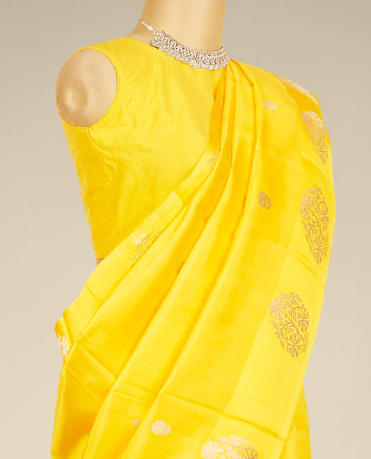 Yellow banaras raw mango silk saree features floral zari buttas, floral design border