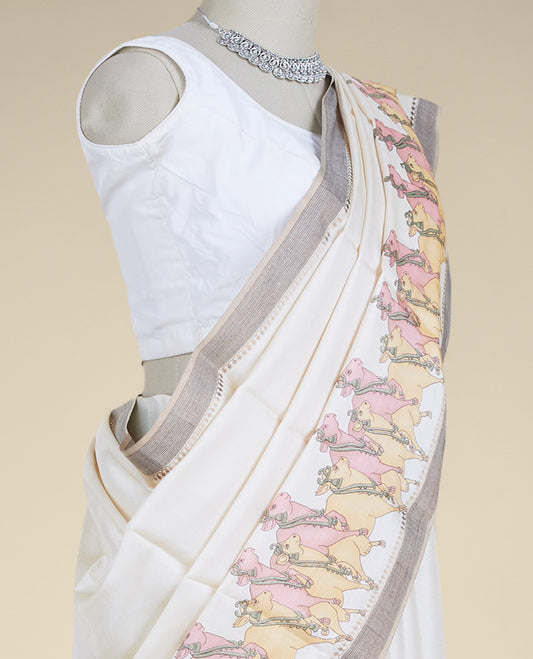 Cream plain design tusser silk saree features pichwai cow motifs, contrast border