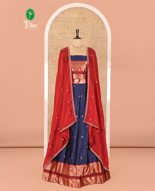 Navy Blue-Red Semi-Banarasi Half-Saree Adorned with Zari Buttas on Its Skirt, Complemented by a Contrast Traditional Zari Temple Rettai Pettu Border, Paired with a Matching Blouse, and a Satin Georgette Embroidered Scallop Dhavani