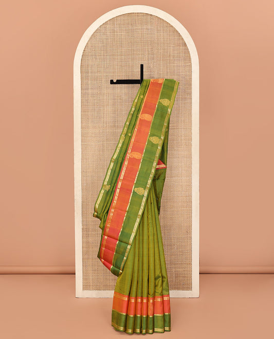 Green Kanchipuram Silk Saree, Mesmerized with Buttas and Vazhaipoo Stripes All Over Its Body, Complemented by a Contrast Border of Muthu, Kathir, and Arumbu Manga Designs, Sparsely Woven Pallu, and Paired with a Contrast Blouse