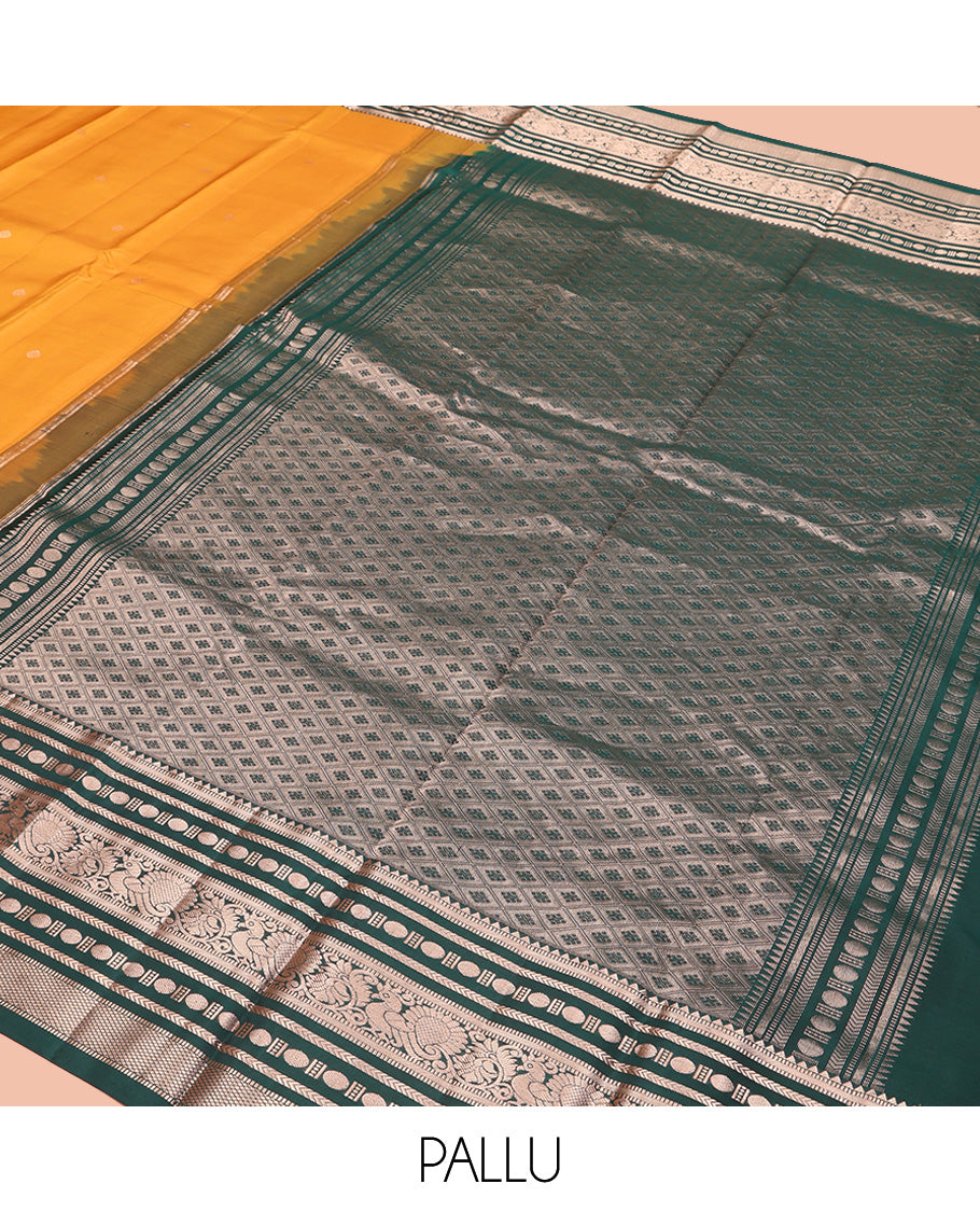 Yellow Vasundhara Silk Saree, Prettified with Zari Buttas All Over Its Body, Complemented by Contrast Border of Rekku, Muthu, Kathir, Poun, Mayil, and Mayil Kann Designs, Grand Jaal Pallu and Paired with a Contrast Blouse