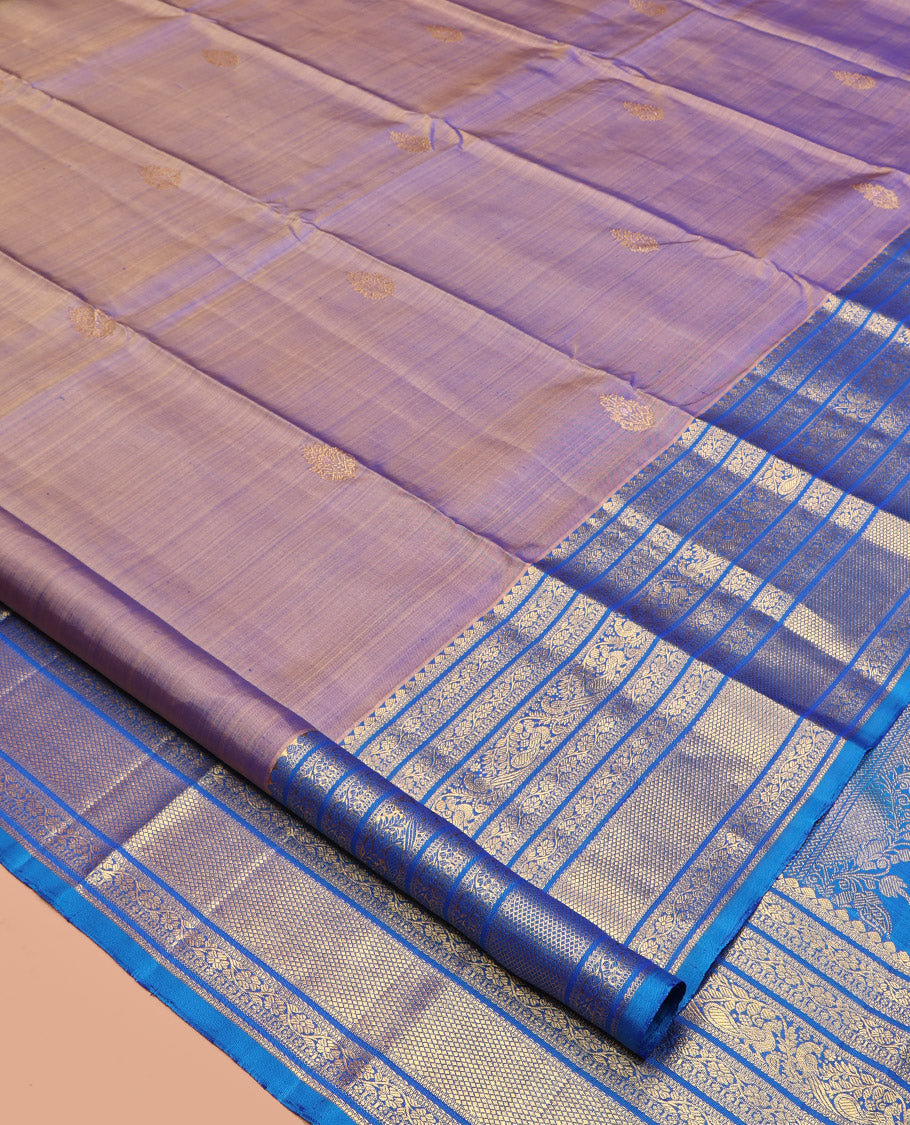 Blue Dual-Tone Kanchipuram Silk Saree, Detailed with Zari Buttas All Over Its Body, Complemented by a Contrast Border of Thilakam Mokku, Kodi Visiry, Mayil, and Kuyil Kann Designs, Grand Pallu of Kodi Visiry Designs, and Paired with a Contrast Blouse