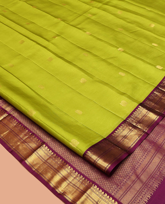 Green Vasundhara Silk Saree, Prettified with Zari Buttas All Over Its Body, Complemented by a Contrast Border of Thilakam, Manga, Muthu, Ara Bogudi, and Mayil Kann Designs, Grand Pallu, and Paired with a Contrast Blouse