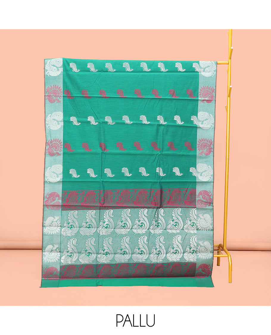 Green Semi-Silk Cotton Saree, Styled with Peacock Buttas All Over Its Body, Highlighted by a Self-Border  of Peacock Designs, Pallu Steeped with Peacock Zari Design, and Paired with a Matching Blouse