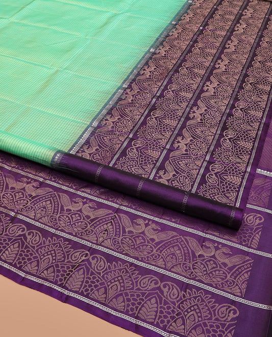 Sea Green Kanchipuram Silk Saree Sparsely Sparkled Checks on Its Body, Complemented by a Contrast Border of Floral, Paisley, and Peacock Designs, Pallu Featuring Diagonal Stripes, and Paired with a Contrast Blouse