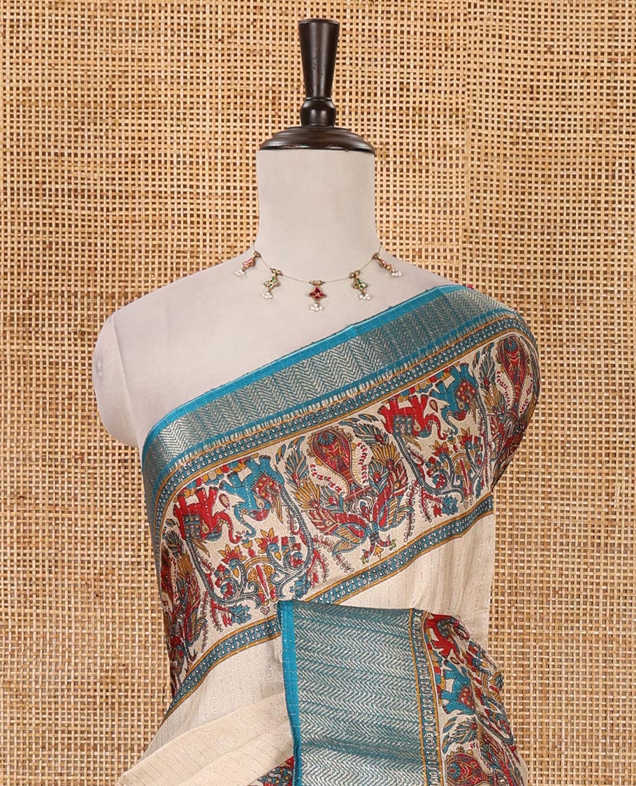 Chikku striped & printed dola silk saree, contrast blue traditional zari border & pallu of elephant & peacock print & contrast printed blouse