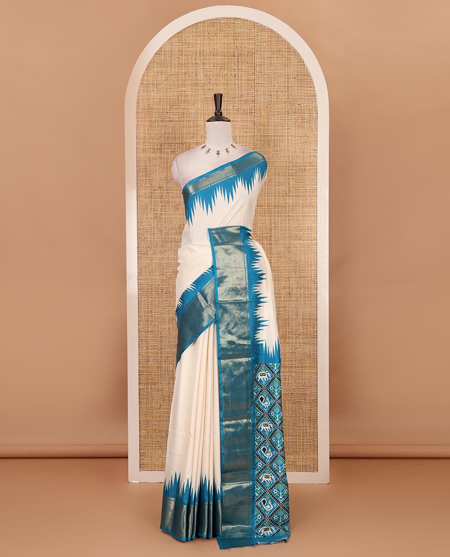 Cream-blue plain dola-tussar saree, contrast temple zari border, patola animal motifs enclosed jaal printed pallu & patola printed blouse