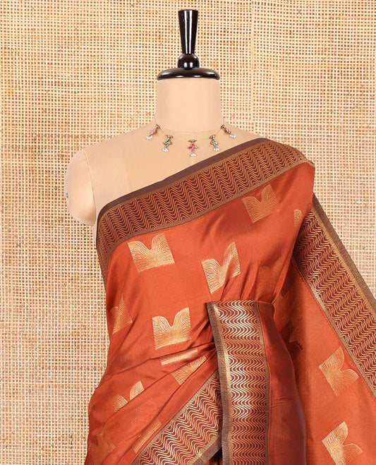 Rust Orange Kanchi Silk Saree Adorned with Zari Buttas All Over Its Body, Complemented by a Contrast Geometric-Patterned Border, Grand Pallu with Intricate Ogee Patterns, and Paired with a Contrast Blouse