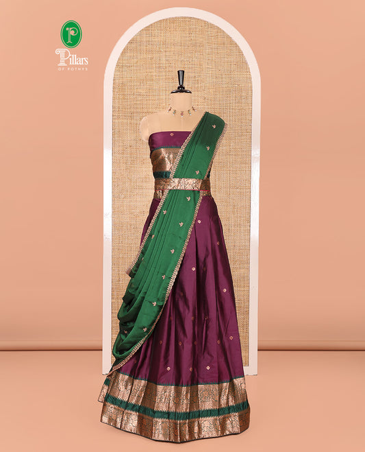 Purple-Green Semi-Banarasi Half-Saree Featuring Zari Buttas on Its Skirt, Complemented by a Contrast Traditional Zari Temple Rettai Pettu Border, Paired with a Matching Blouse, and a Satin Georgette Embroidered Scallop Dhavani