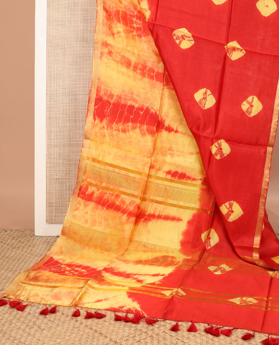 Red and yellow shibori printed banana pith saree, zari piping border, and zari striped pallu