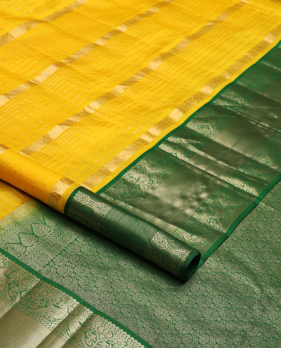 Yellow zari design silk saree, contrast border of reeku, lavangam, and kili designs, and  ogee patterned pallu