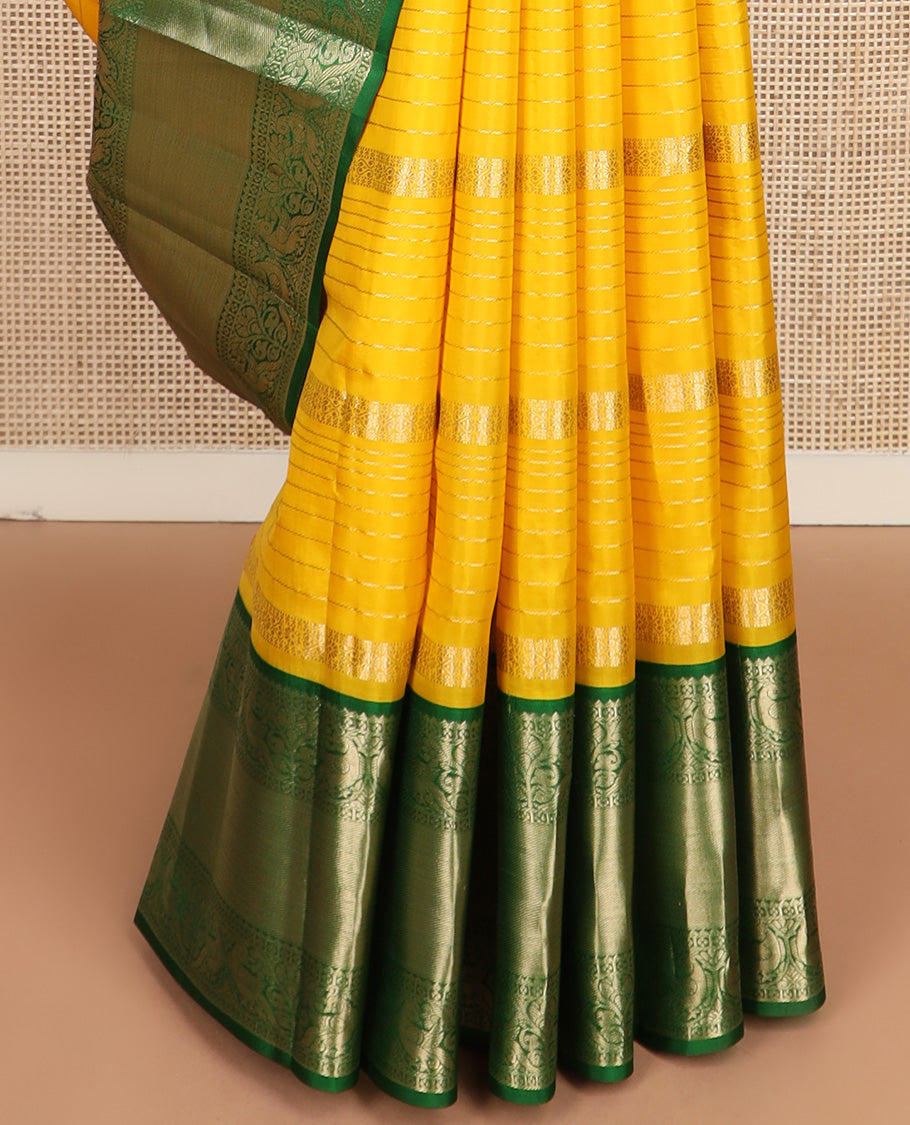 Yellow zari design silk saree, contrast border of reeku, lavangam, and kili designs, and  ogee patterned pallu