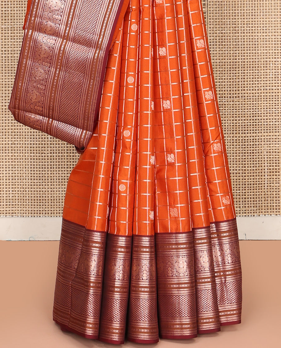 Orange Vasundhara Silk Saree, Meticulously Crafted with Zari Butta Enclosed Checks, Complemented by Contrast Border of Thilakam Mokku, Rettai Neli, Iruthalai Pakshi, and Ara Maadam Designs, Grand Jaal Pallu and Paired with a Contrast Blouse