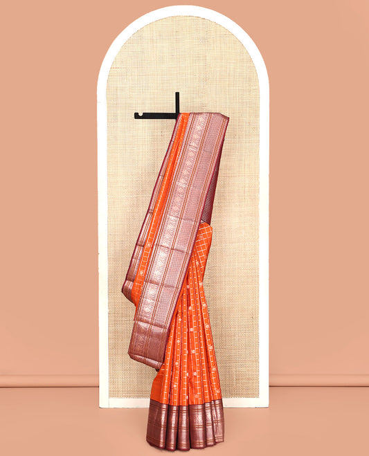 Orange Vasundhara Silk Saree, Meticulously Crafted with Zari Butta Enclosed Checks, Complemented by Contrast Border of Thilakam Mokku, Rettai Neli, Iruthalai Pakshi, and Ara Maadam Designs, Grand Jaal Pallu and Paired with a Contrast Blouse