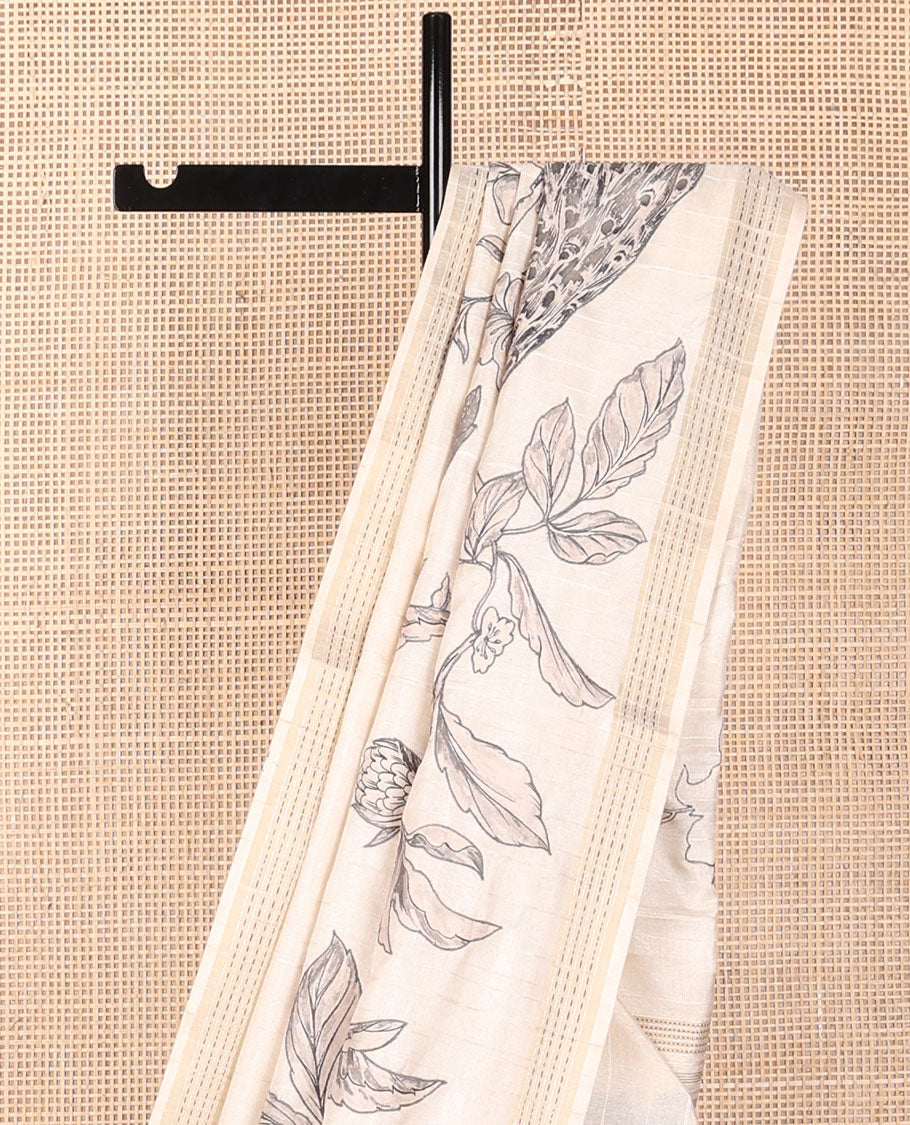 Cream printed tussar saree mirrors the peacock on the floral vine design and has a zari border and zari striped pallu