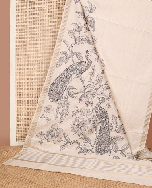 Cream printed tussar saree mirrors the peacock on the floral vine design and has a zari border and zari striped pallu