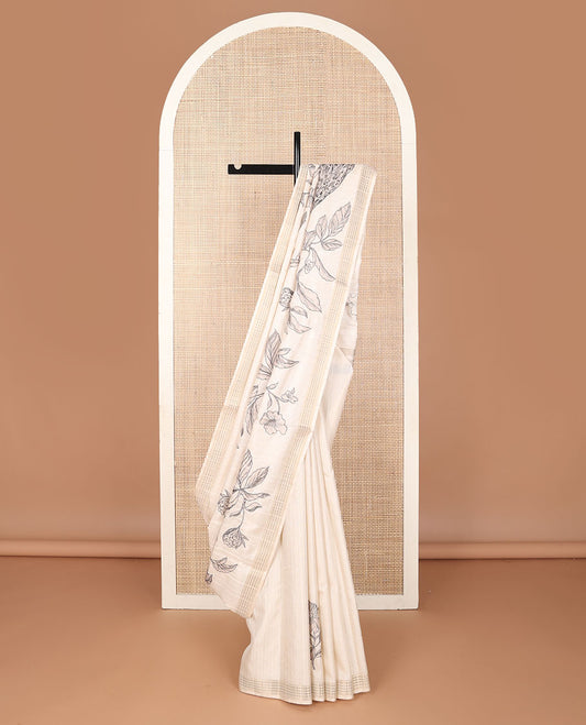 Cream printed tussar saree mirrors the peacock on the floral vine design and has a zari border and zari striped pallu