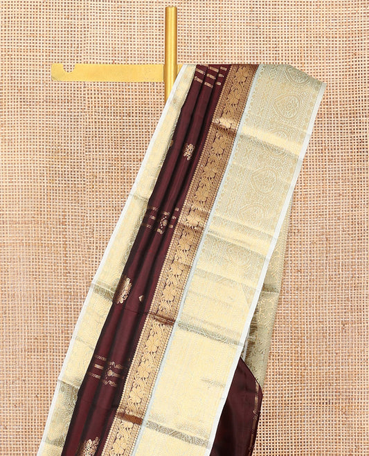 Maroon Vasundhara Silk Saree, Enthralled with Zari Buttas and Zari Design All Over Its Body, Complemented by a Contrast Border of Traditional Designs, Sparsely Sparkled Pallu of Thilakam Designs, and Paired with a Contrast Blouse
