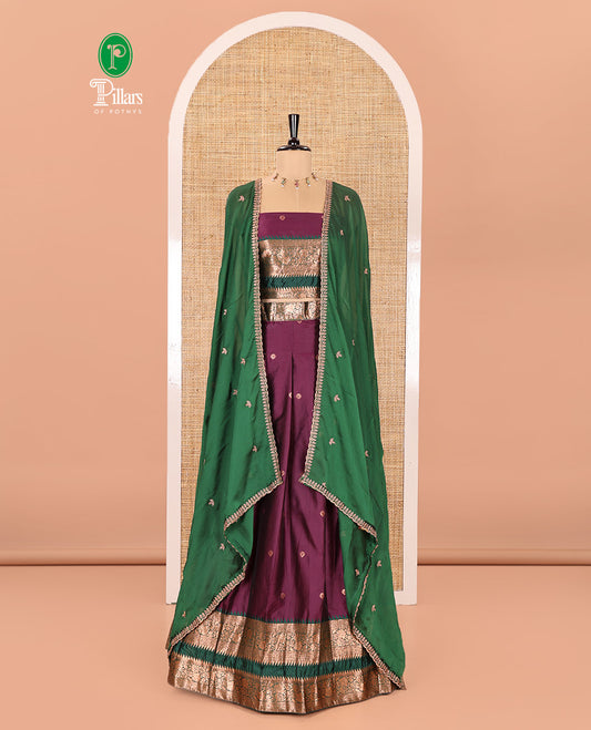Purple-Green Semi-Banarasi Half-Saree Featuring Zari Buttas on Its Skirt, Complemented by a Contrast Traditional Zari Temple Rettai Pettu Border, Paired with a Matching Blouse, and a Satin Georgette Embroidered Scallop Dhavani