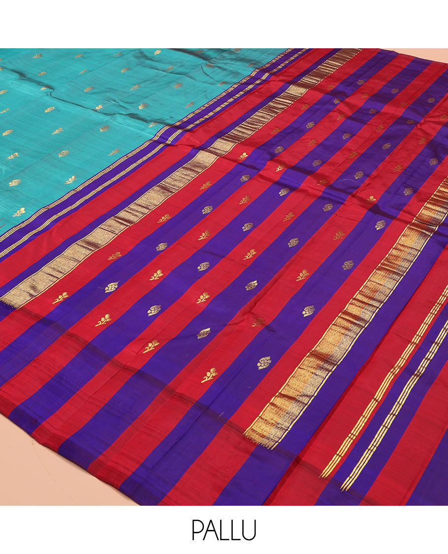 Blue Kanchipuram Silk Saree, Elevated with Zari Buttas on Its Body, Complemented by a Contrast One-Sided Thazampoo Rekku Border of Zari Buttas, Pallu Steeped with Zari Designs, and Comes Without a Blouse