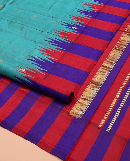 Blue Kanchipuram Silk Saree, Elevated with Zari Buttas on Its Body, Complemented by a Contrast One-Sided Thazampoo Rekku Border of Zari Buttas, Pallu Steeped with Zari Designs, and Comes Without a Blouse
