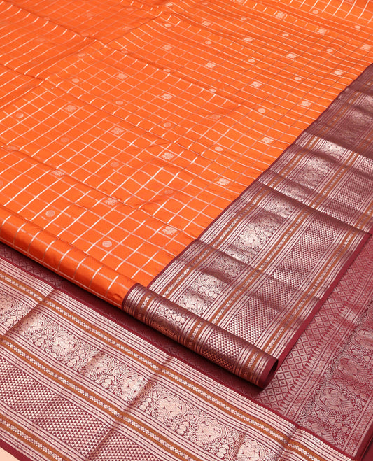 Orange Vasundhara Silk Saree, Meticulously Crafted with Zari Butta Enclosed Checks, Complemented by Contrast Border of Thilakam Mokku, Rettai Neli, Iruthalai Pakshi, and Ara Maadam Designs, Grand Jaal Pallu and Paired with a Contrast Blouse