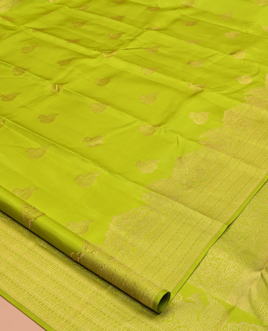 Parrot Green Kanchipuram Silk Saree, Gleamed Up with Zari Buttas All Over Its Body, Highlighted by a Zari Border of Mayil, Yaanai, and Neli Designs, Intricately Designed Pallu, and Paired with a Matching Blouse