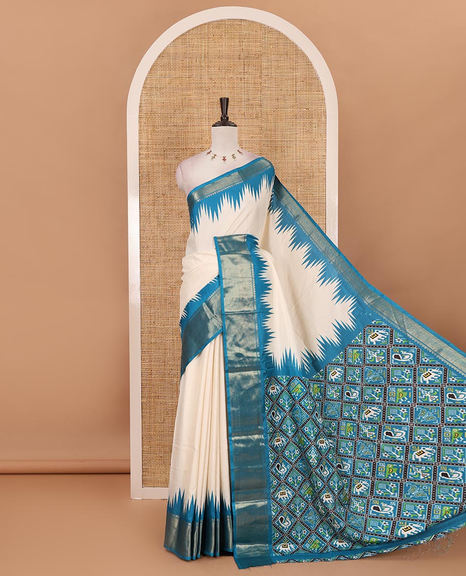Cream-blue plain dola-tussar saree, contrast temple zari border, patola animal motifs enclosed jaal printed pallu & patola printed blouse